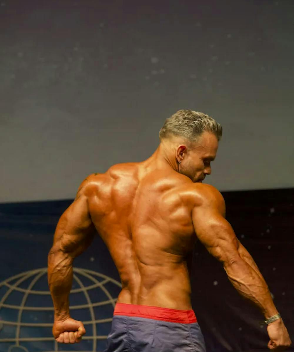 Edison Ramirez, coach sportif à Neuchatel pose et montre son dos à un compétition de fitness professionnelle